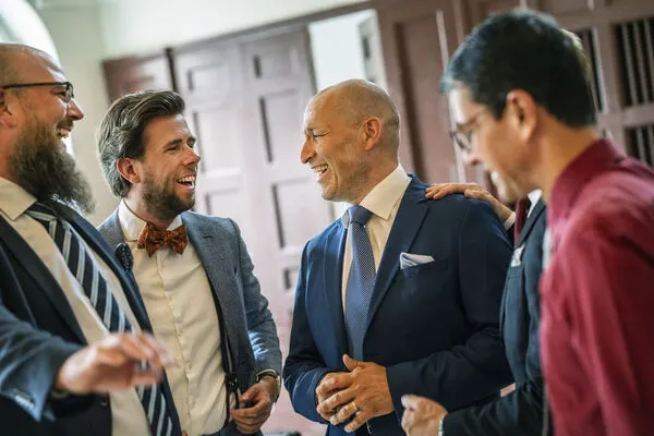 Four men talking and laughing. Photo.
